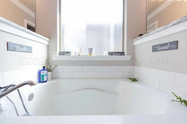 a bathroom with a bathtub and next to a window