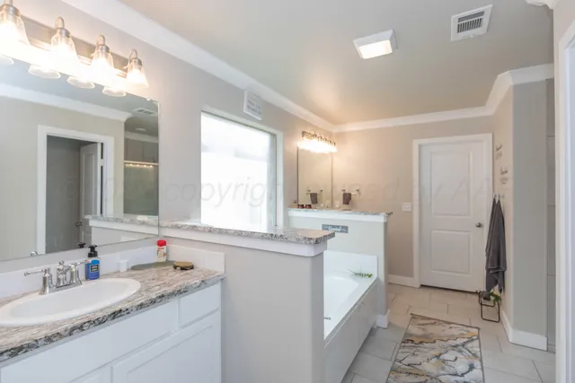 a bathroom with a granite countertop double vanity sink mirror and double