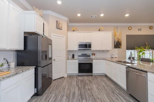 a kitchen with stainless steel appliances a refrigerator sink and microwave
