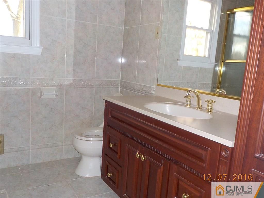 8 Higgins Road Old Bridge, NJ 08857 - Photo 8 of 15 a bathroom with a sink a toilet and mirror