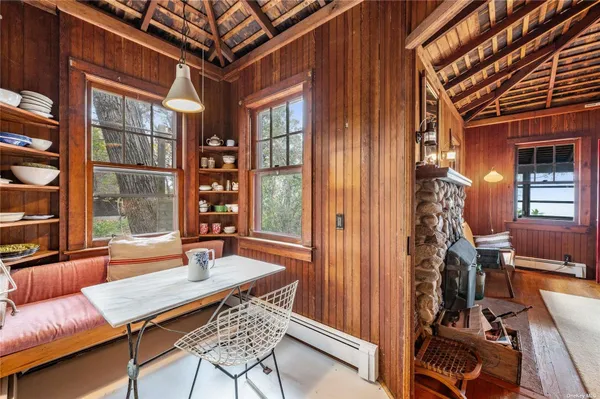 a living room with furniture two window and wooden floor