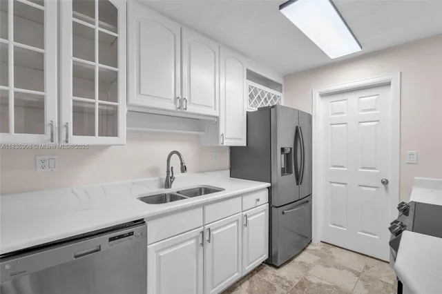 a kitchen with stainless steel appliances a refrigerator and sink
