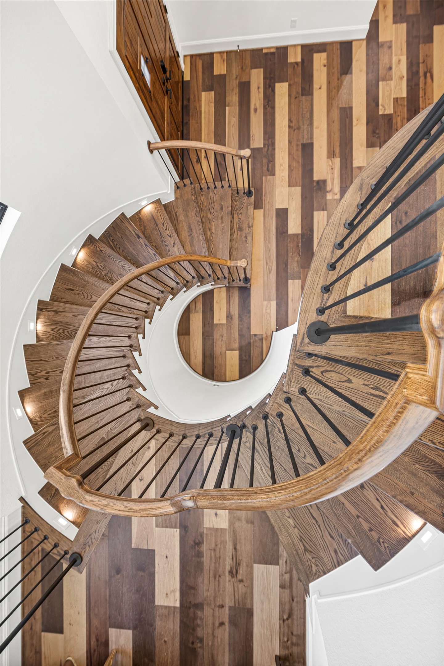 19314 Chateau Ridge Court Tomball, TX 77377 - Photo 25 of 50 Striking spiral staircase crafted with warm wood treads and iron detailing, providing a beautiful architectural transition from the downstairs creative space to the second floor.