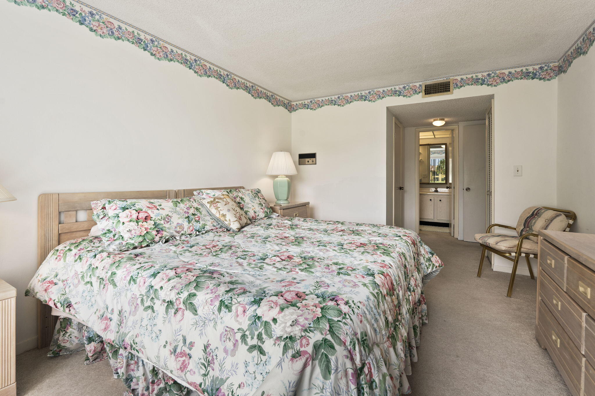 5413 Southeast Miles Grant Road, Unit G206 Stuart, FL 34997 - Photo 13 of 31 a bedroom with a bed and a dresser with the shoe rack