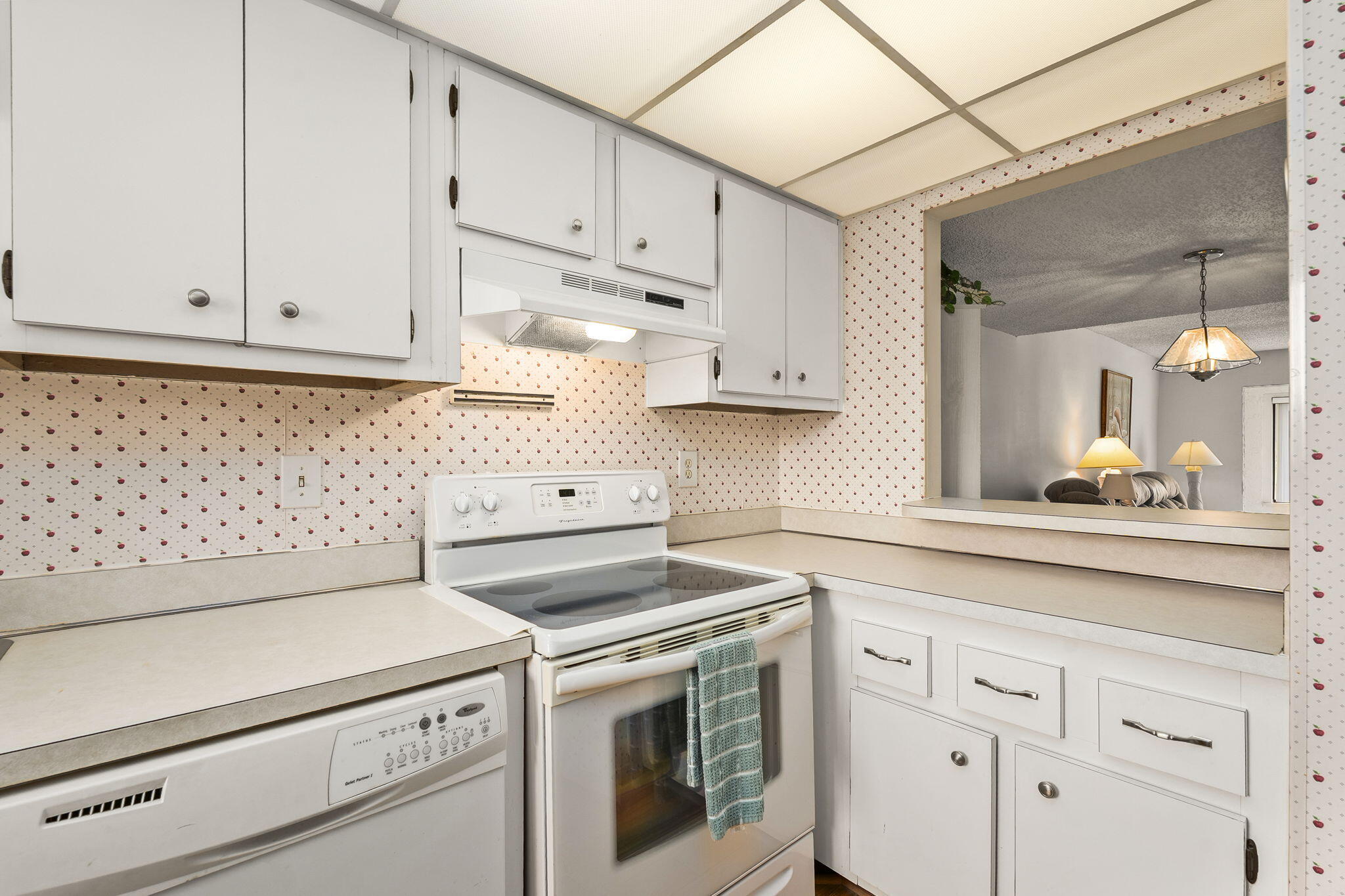 5413 Southeast Miles Grant Road, Unit G206 Stuart, FL 34997 - Photo 16 of 31 a kitchen with white cabinets and white appliances