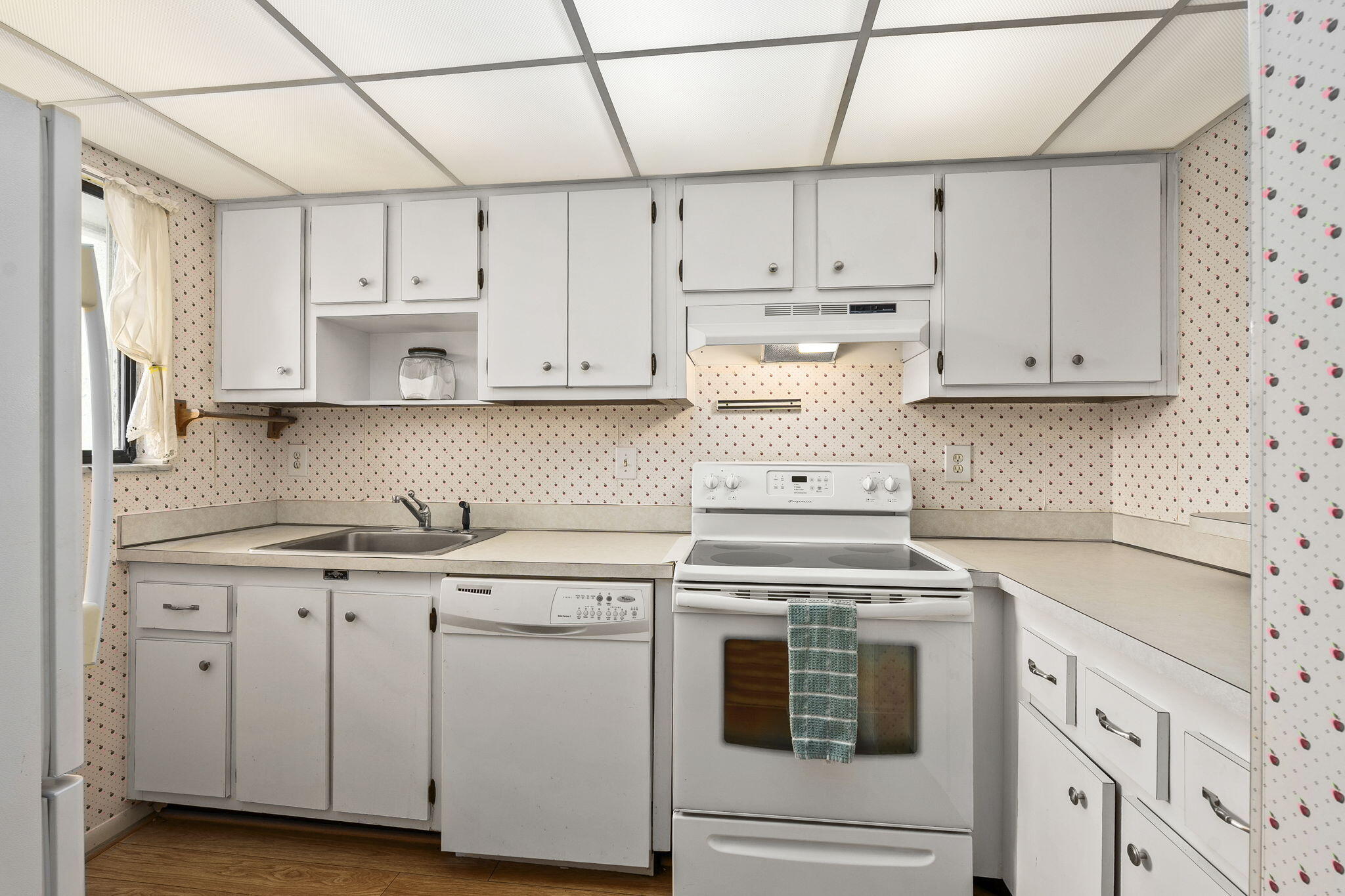 5413 Southeast Miles Grant Road, Unit G206 Stuart, FL 34997 - Photo 17 of 31 a kitchen with granite countertop white cabinets and white appliances