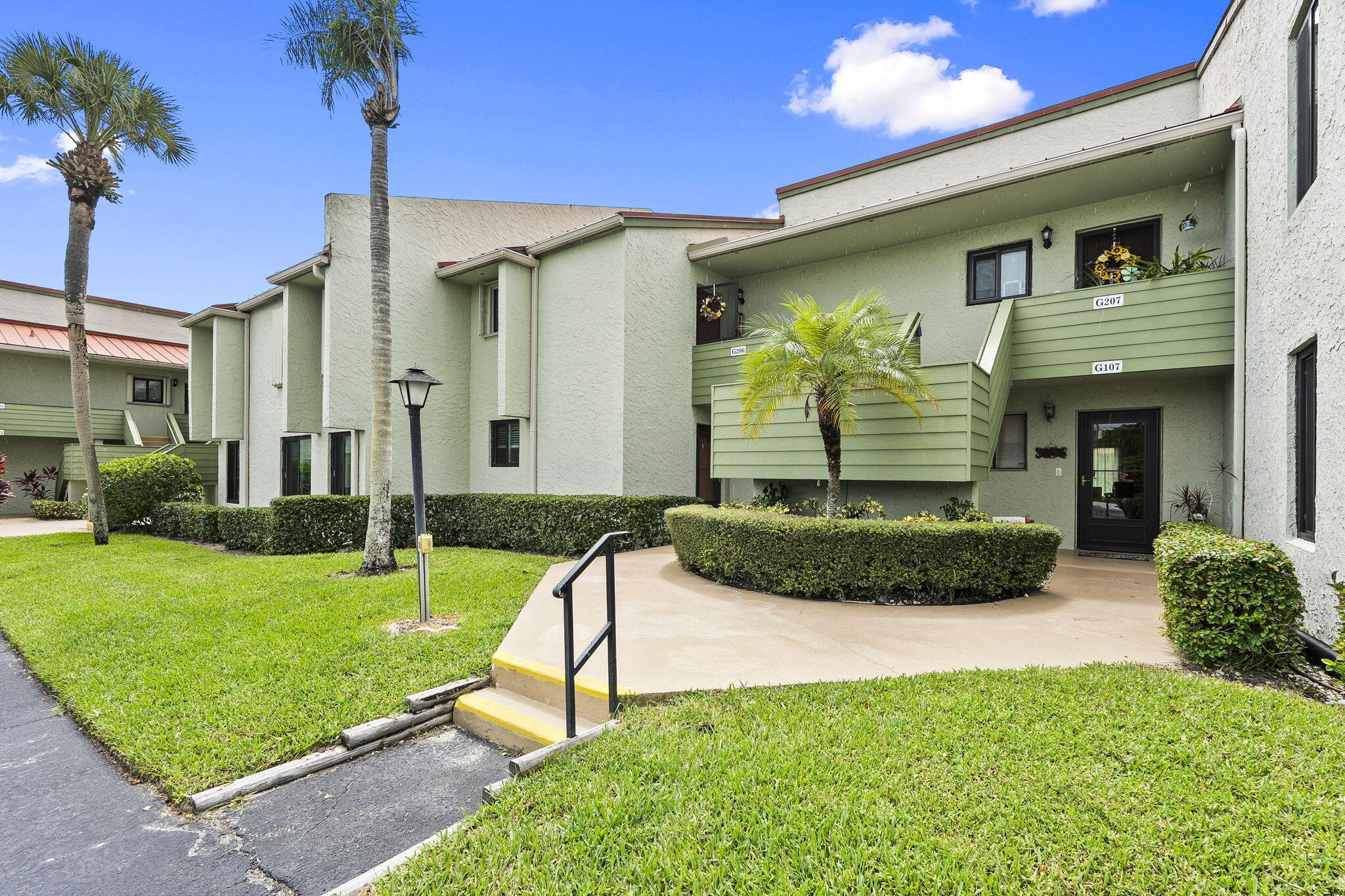 5413 Southeast Miles Grant Road, Unit G206 Stuart, FL 34997 - Photo 2 of 31 a view of a house with a yard and potted plants