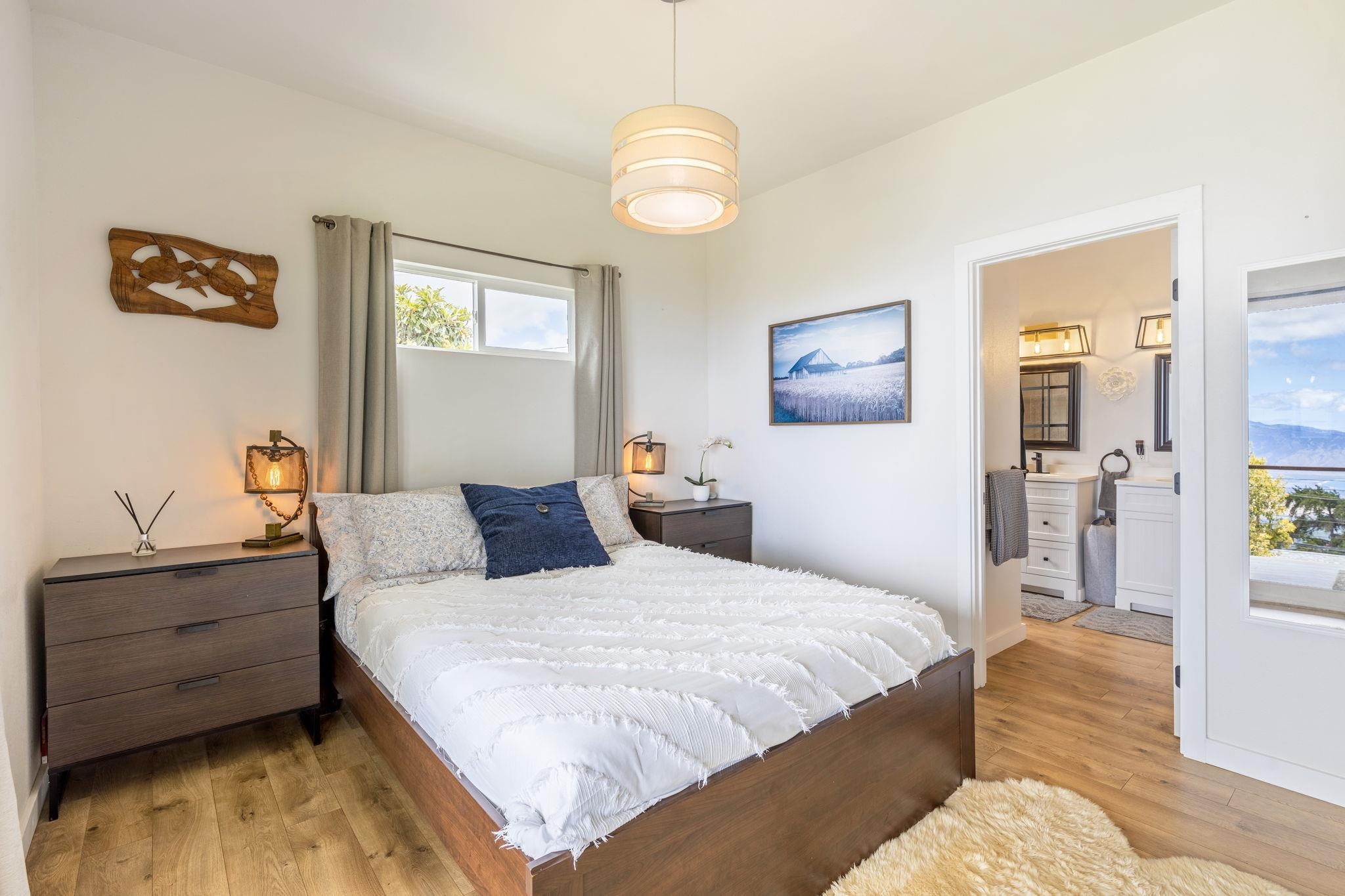 59 Waipoli Road Kula, HI 96790 - Photo 22 of 47 a bedroom with a bed and a chandelier