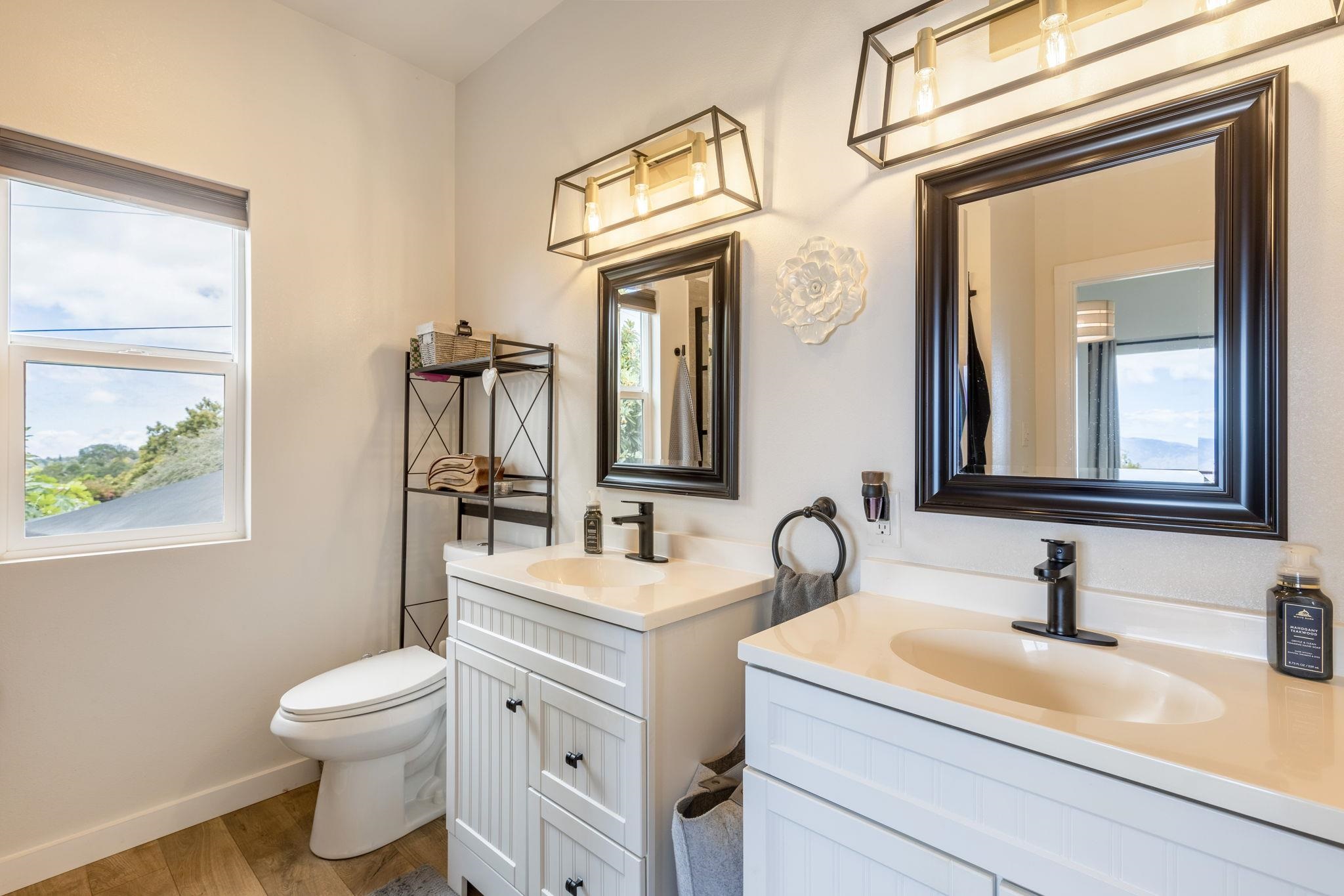 59 Waipoli Road Kula, HI 96790 - Photo 24 of 47 a bathroom with a granite countertop toilet a sink and a mirror