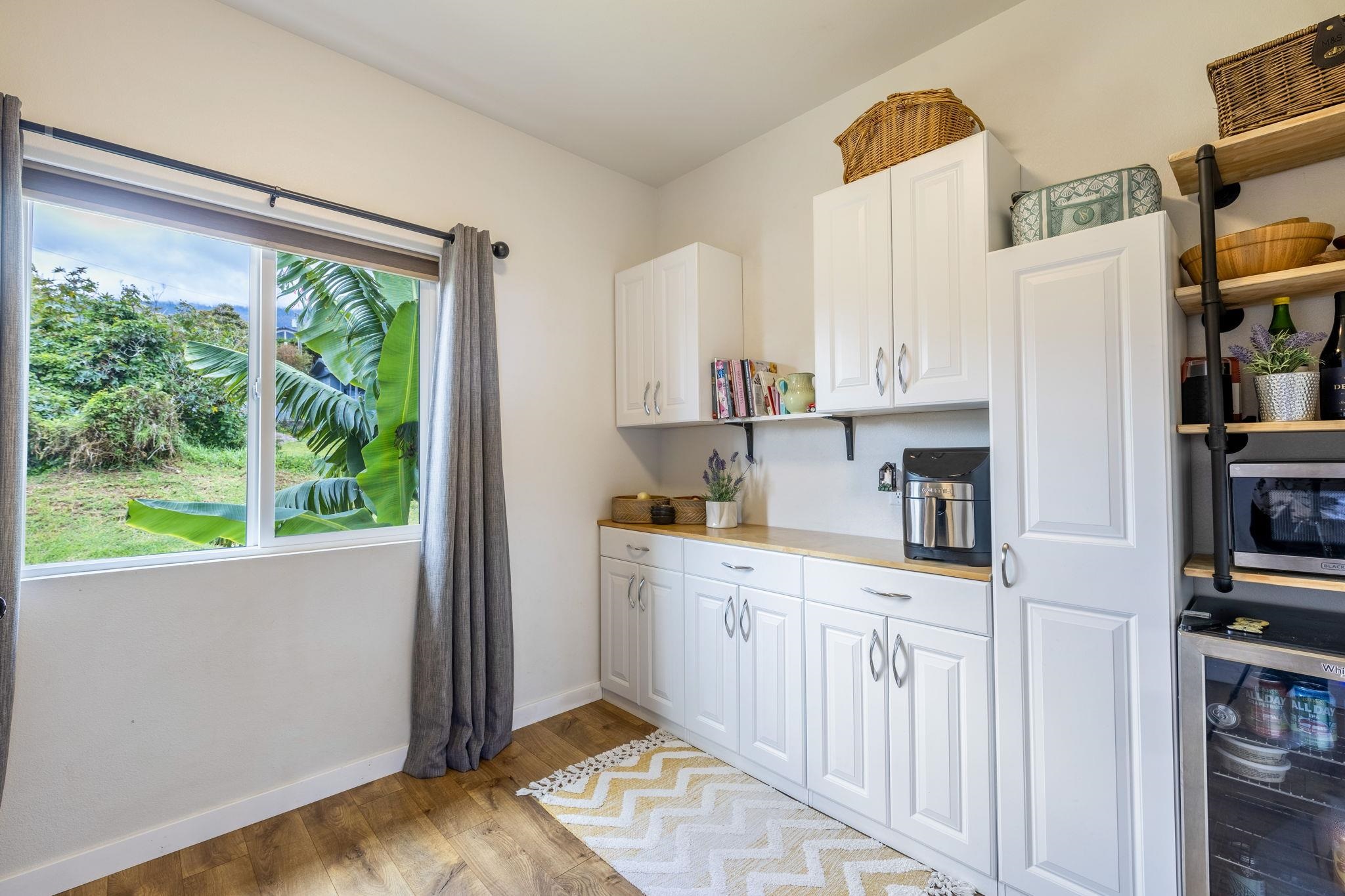 59 Waipoli Road Kula, HI 96790 - Photo 27 of 47 a kitchen with stainless steel appliances a white cabinets and a rug