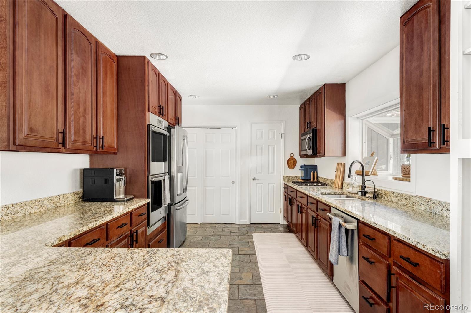 23233 Valley High Road Morrison, CO 80465 - Photo 4 of 43 a kitchen with stainless steel appliances granite countertop a sink stove and cabinets
