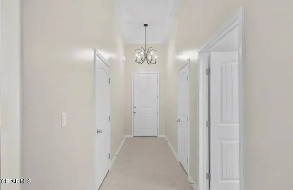 a view of a hallway with chandelier and entryway