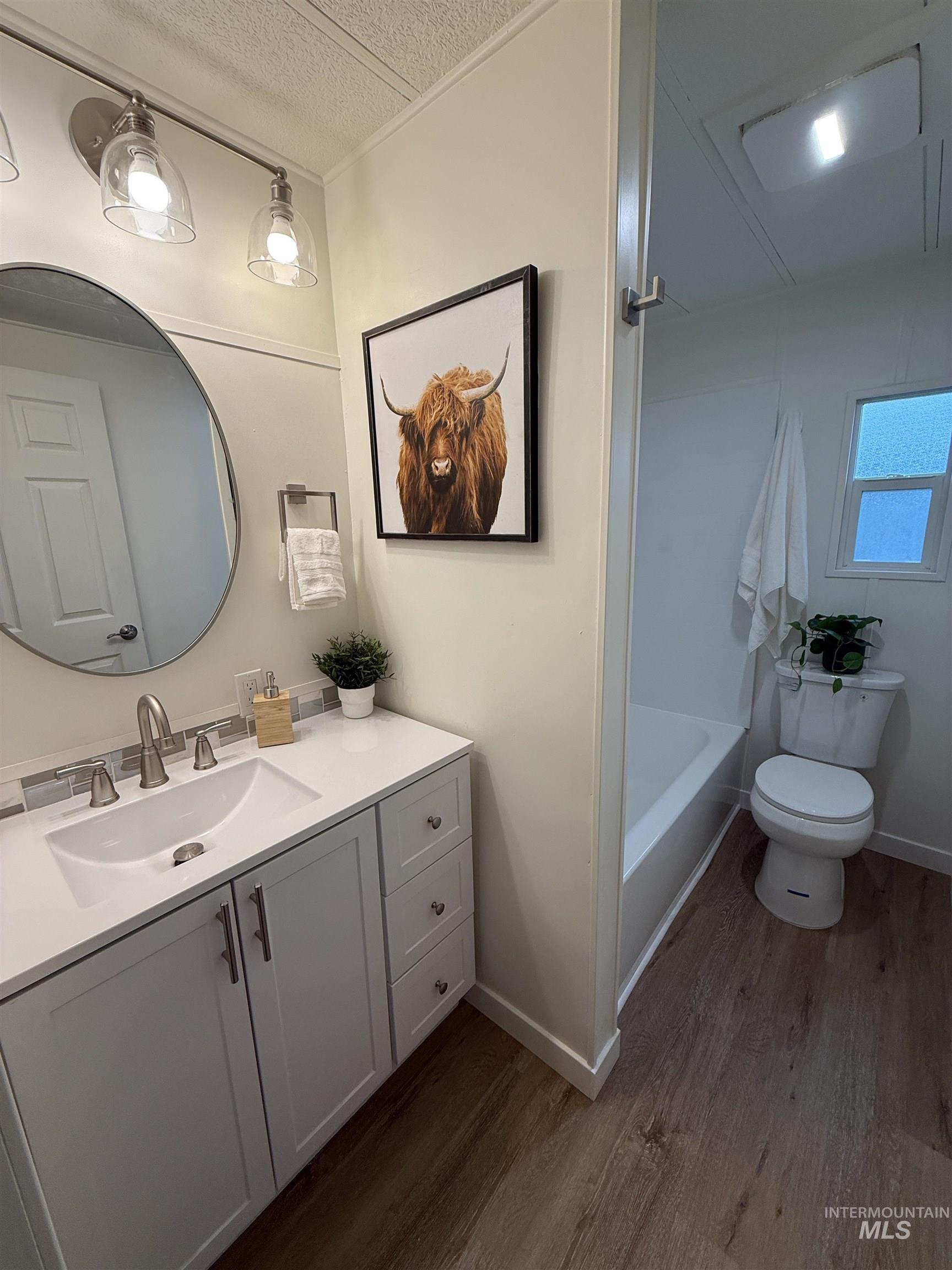 424 West Cherry Lane, Unit 5 Meridian, ID 83642 - Photo 23 of 27 Full bath featuring vanity, dark wood-style floors, a textured ceiling, and tub / shower combination