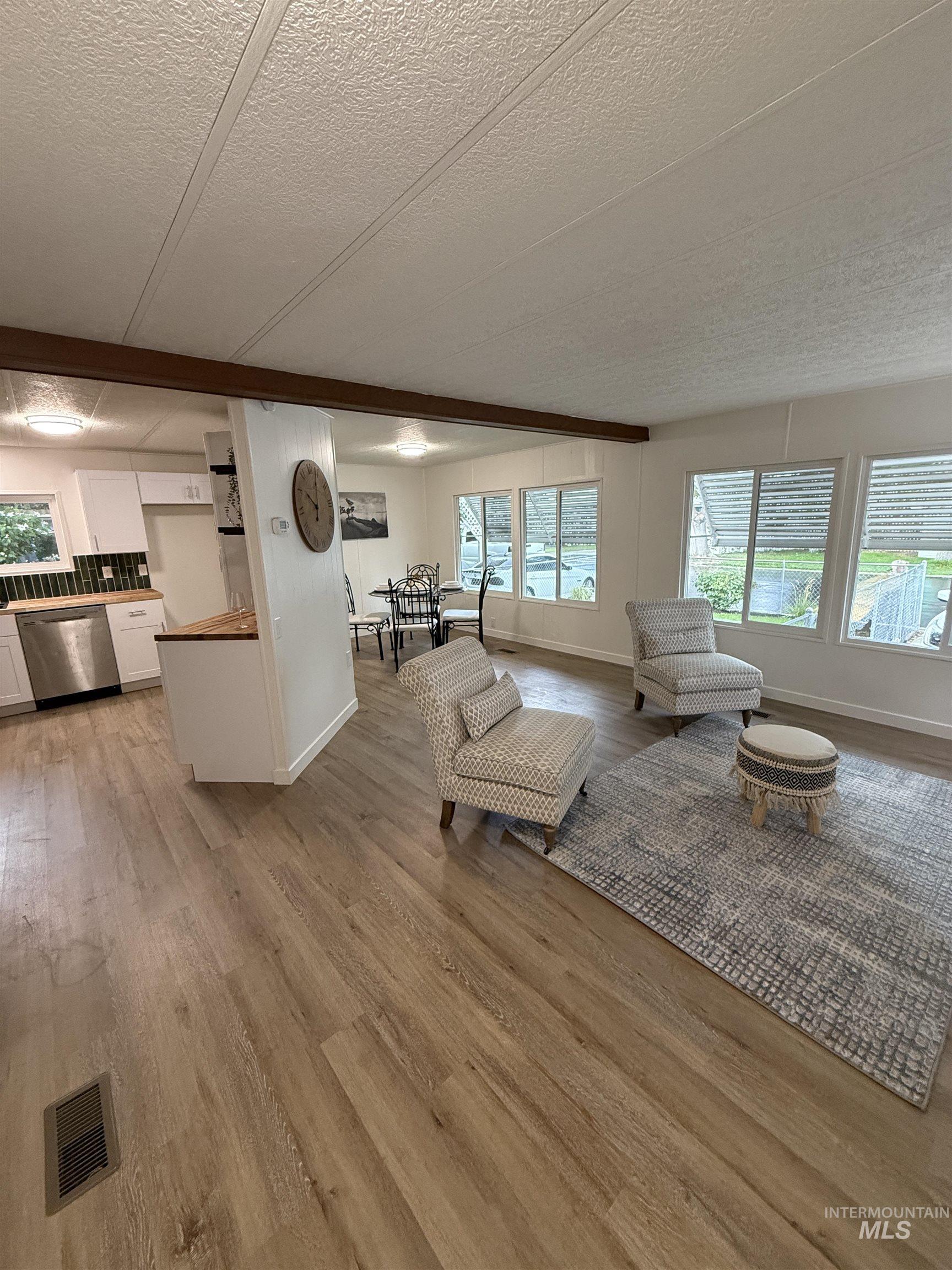 424 West Cherry Lane, Unit 5 Meridian, ID 83642 - Photo 3 of 27 Living room featuring light wood finished floors and a textured ceiling