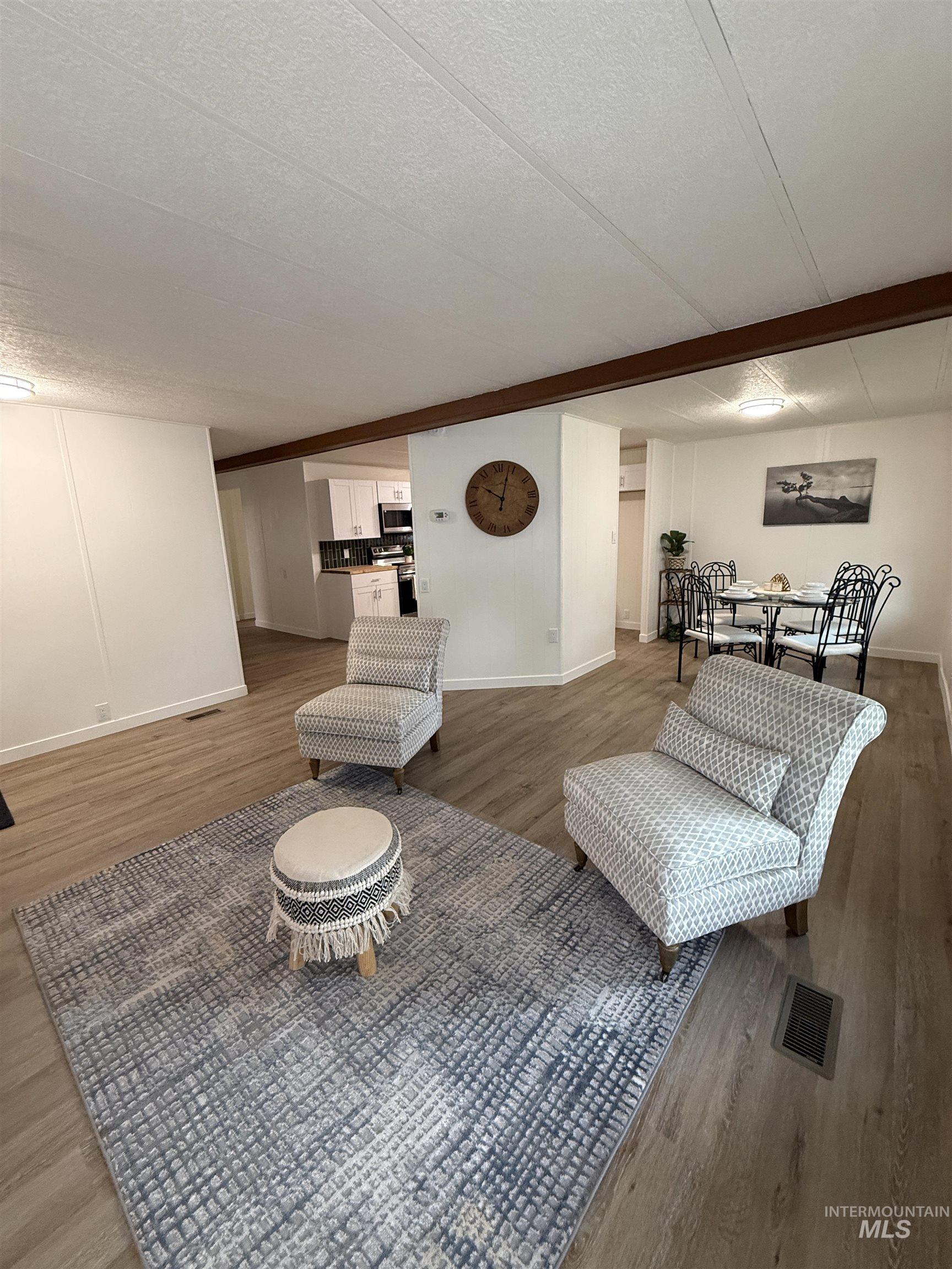 424 West Cherry Lane, Unit 5 Meridian, ID 83642 - Photo 4 of 27 Living room with a textured ceiling, wood finished floors, and beamed ceiling
