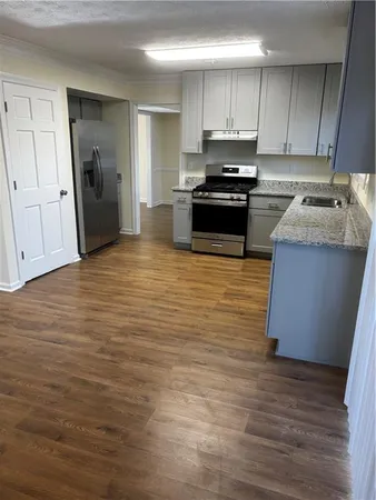 a kitchen with stainless steel appliances granite countertop a stove a sink and a refrigerator