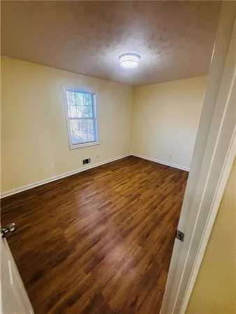a view of empty room with wooden floor and closet