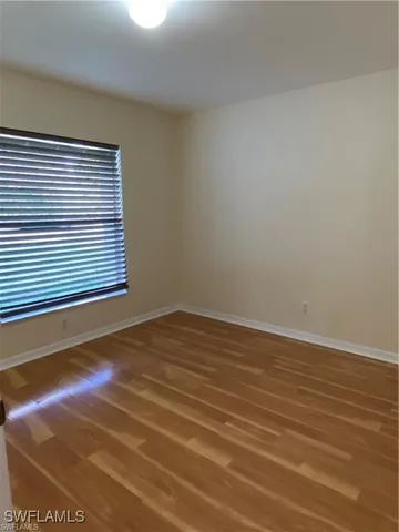 a view of a room with wooden floor and a window