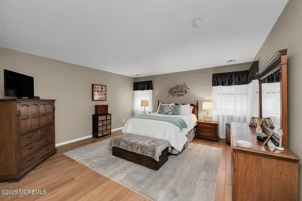 a spacious bedroom with a bed and flat screen tv