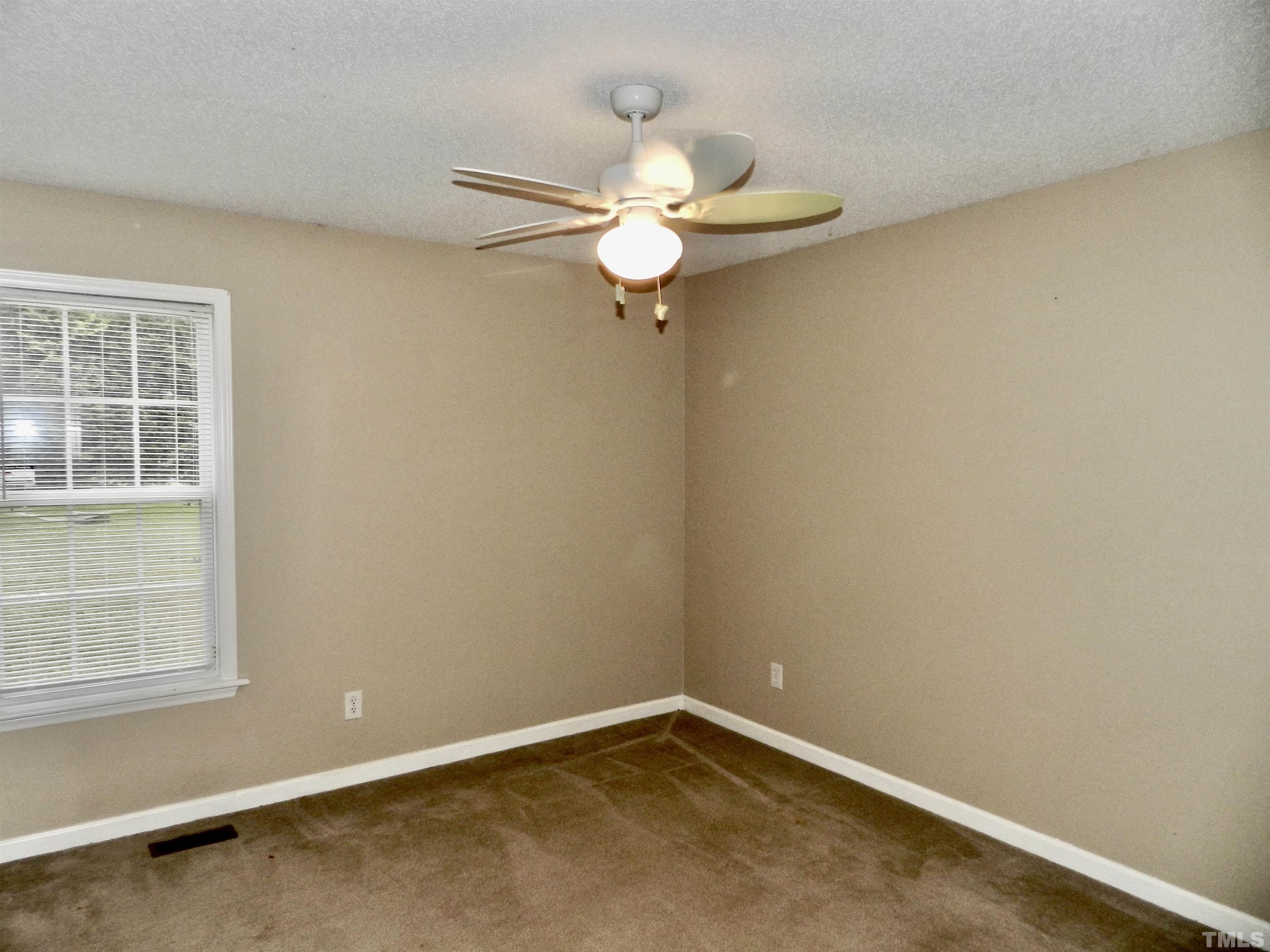 316 Amber Lane Willow Spring, NC 27592 - Photo 13 of 18 an empty room with windows and fan