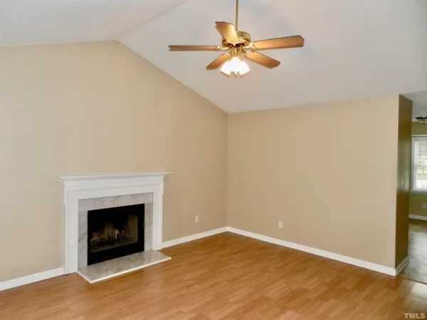 an empty room with a fireplace and fan
