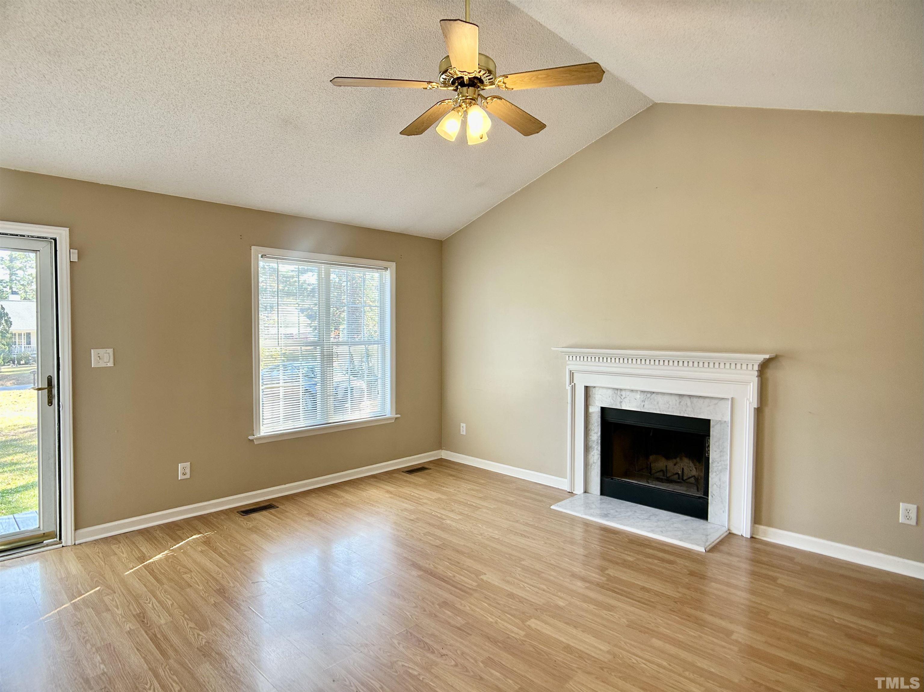 316 Amber Lane Willow Spring, NC 27592 - Photo 3 of 18 an empty room with chandelier fan and windows