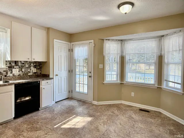 a view of an empty room with a kitchen