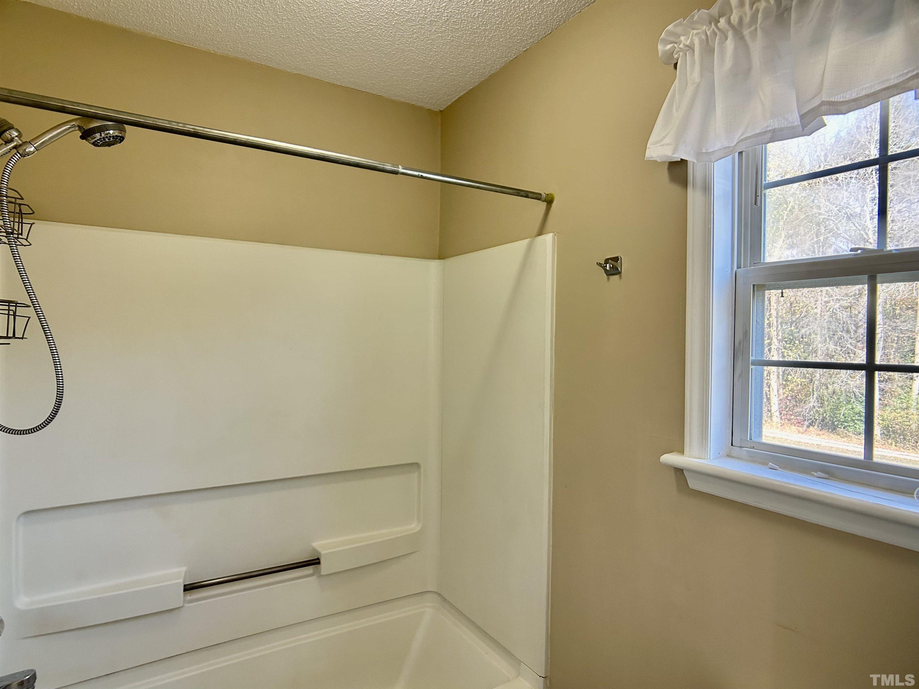 316 Amber Lane Willow Spring, NC 27592 - Photo 9 of 18 a bathroom with a shower and a window