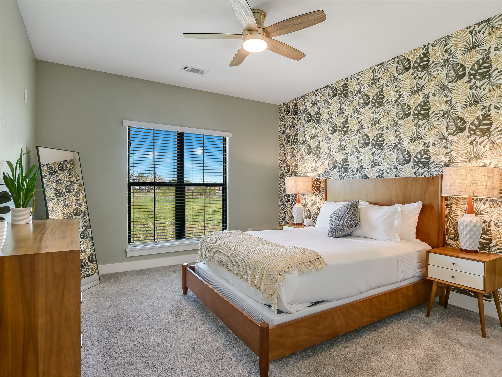 19819 Lockwood Road Manor, TX 78653 - Photo 14 of 29 Personality shines in this secondary bedroom, where bold wallpaper and peaceful pasture views create a space guests will love and kids will claim as their own.