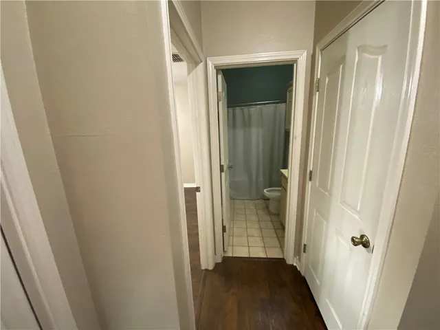 an empty room with wooden floor and ceiling fan