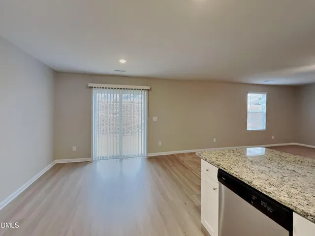 an empty room with wooden floor and window