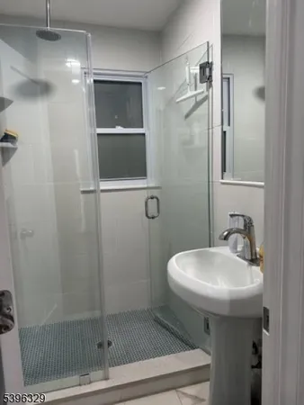 a bathroom with a sink shower and mirror