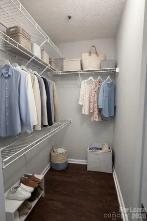 a view of walk in closet with clothes and shoes