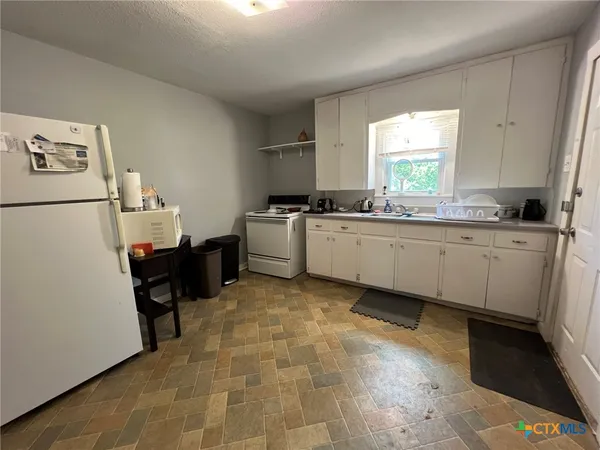 a kitchen with a sink a stove and a refrigerator
