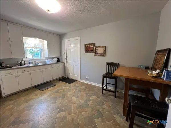 a kitchen with a sink cabinets and wooden floor