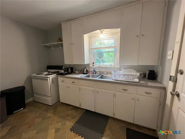 a kitchen with sink cabinets and window