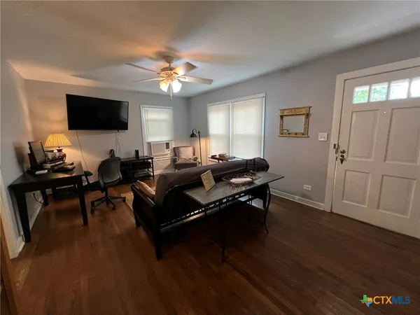 a living room with furniture a flat screen tv and a window