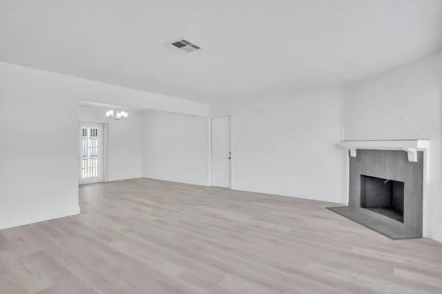 a view of empty room with wooden floor and fireplace