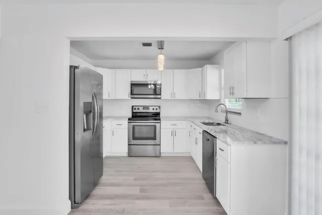 a kitchen with kitchen island a sink stainless steel appliances and cabinets