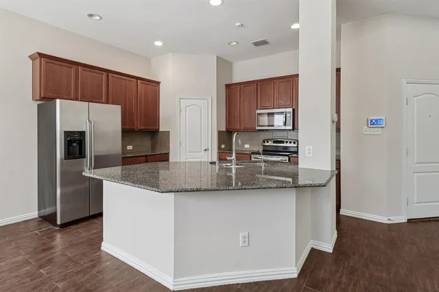 a kitchen with stainless steel appliances granite countertop a stove top oven a sink and dishwasher