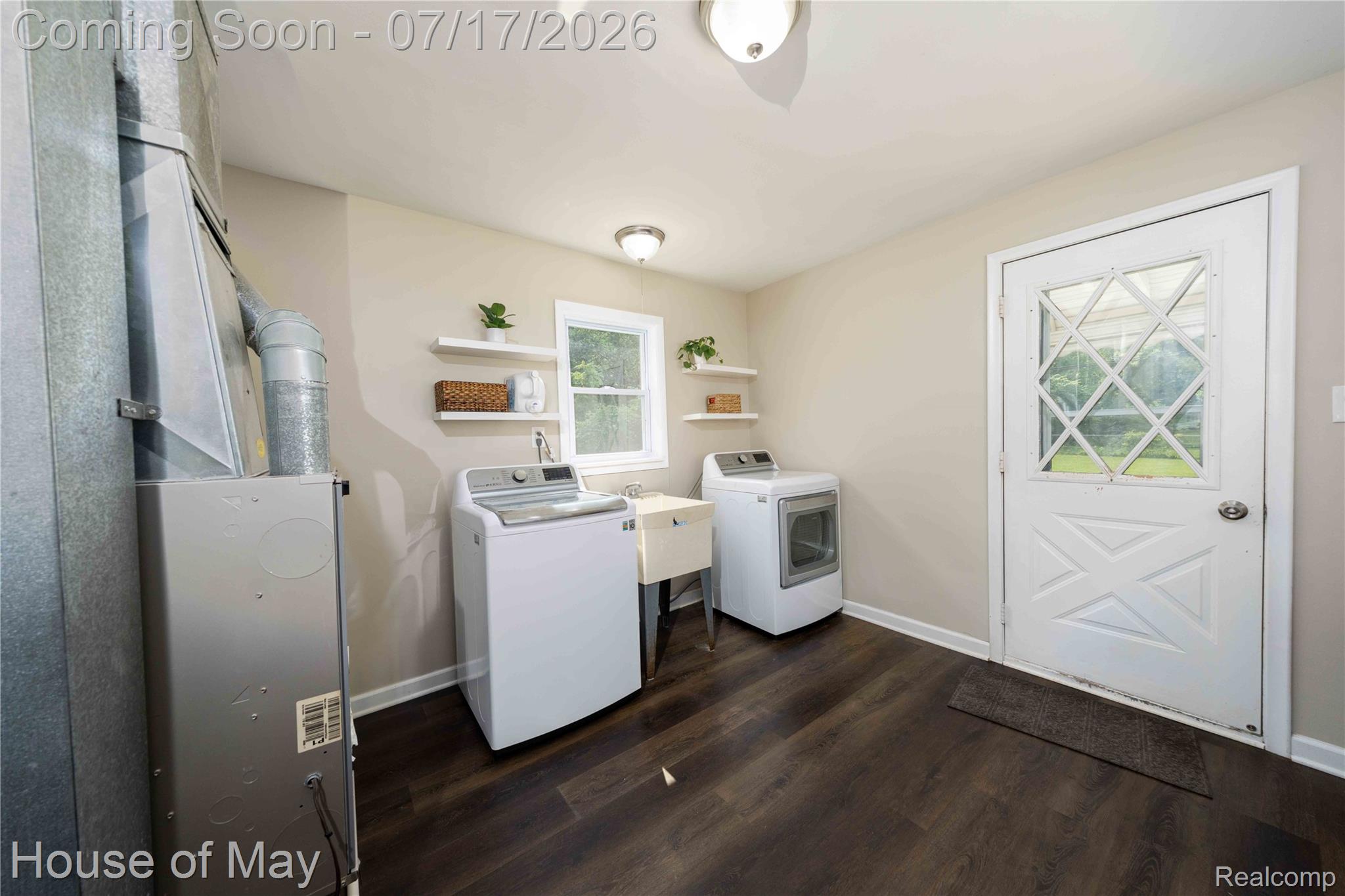 45247 Bemis Road Belleville, MI 48111 - Photo 15 of 28 Utility room featuring dark wood-finish flooring, a utility sink, and a white exterior door with diamond-patterned glass