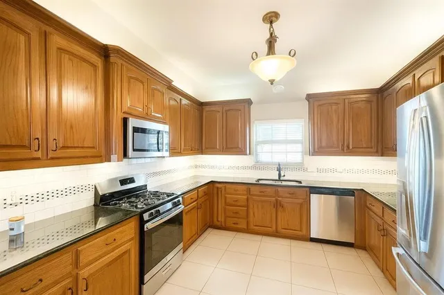 a kitchen with stainless steel appliances granite countertop a sink and cabinets