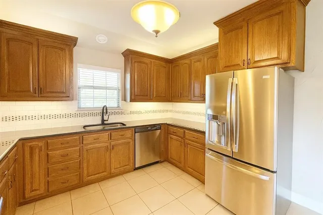 a kitchen with stainless steel appliances granite countertop a refrigerator and a sink