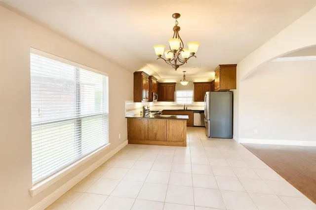 a large kitchen with a large counter space appliances and cabinets