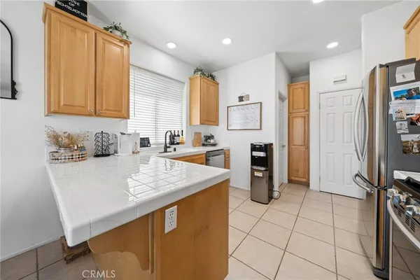 a kitchen with stainless steel appliances granite countertop a sink refrigerator and cabinets