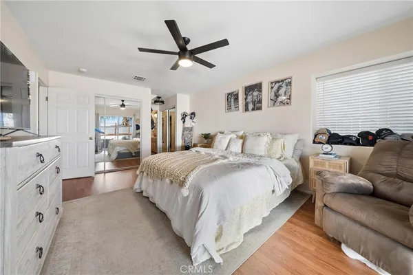 a spacious bedroom with a bed and ceiling fan