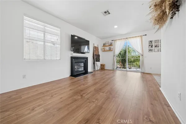 a view of empty room with wooden floor and fireplace