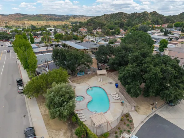 an aerial view of residential house with outdoor space and trees all around