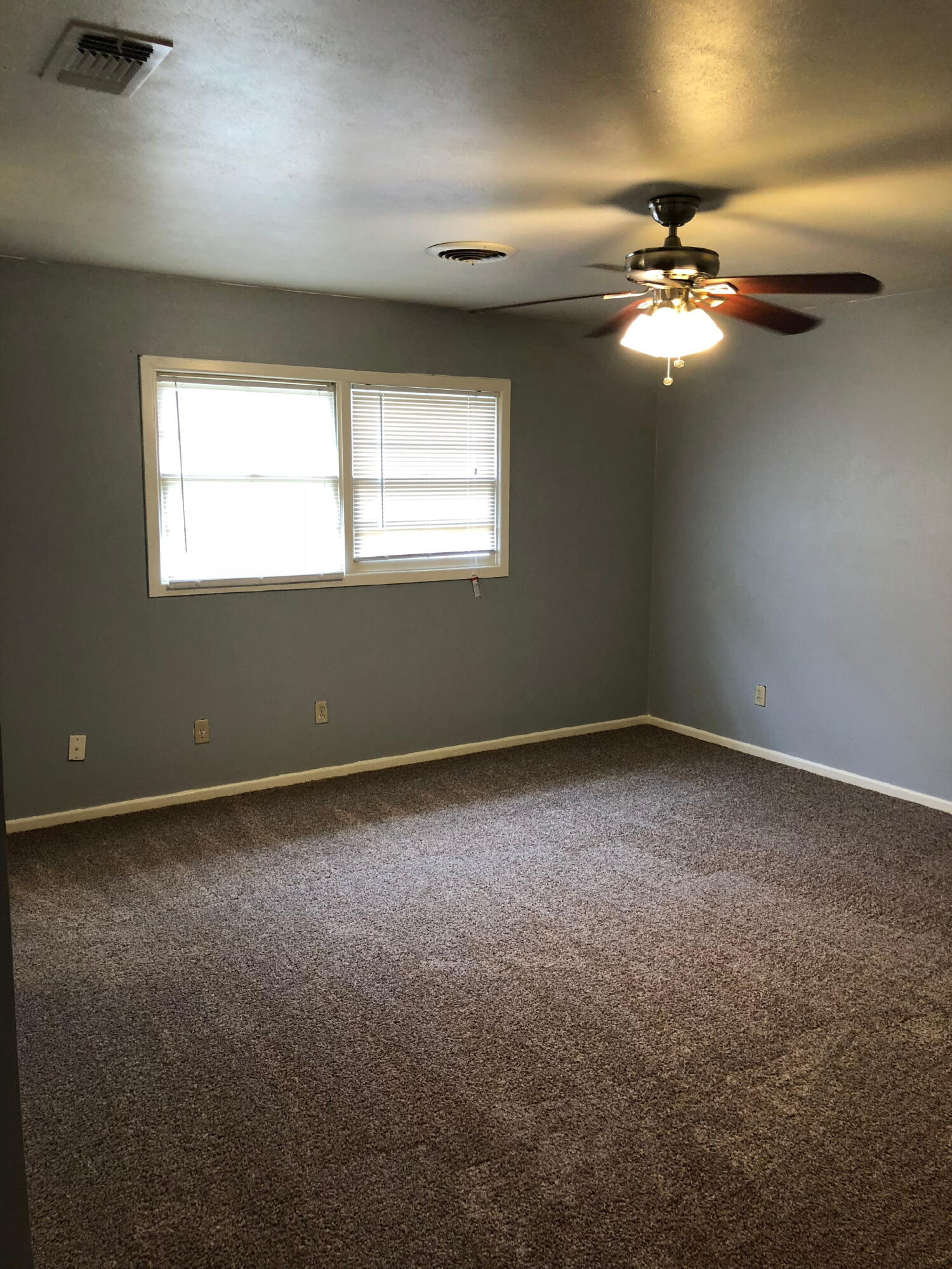 3020 45th Street Lubbock, TX 79413 - Photo 11 of 20 an empty room with a window and a fan