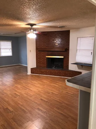 a view of an empty room with a fireplace and a window